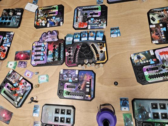 A mess of big chunky dice, cubes, cards, and plastic trays spread out over a table.