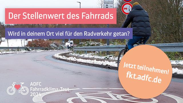 Radfahrender auf einer Straße mit großem fahrradpiktogramm auf der Fahrbahn und Schneeresten am Fahrbahnrand. Ein Verkehrsschild am Straßenrand untersagt das Überholen von Radfahrenden durch mehrspurige Kraftfahrzeuge.