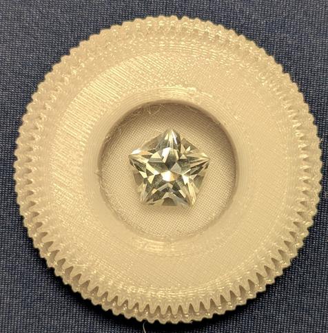 A picture of an 80 tooth gear made from PETG with  finished star faceted stone in the center of it.