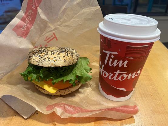 Tim Horton’s bagel sandwich with egg and bacon and cheese and lettuce. A BELT. And a medium coffee cup.