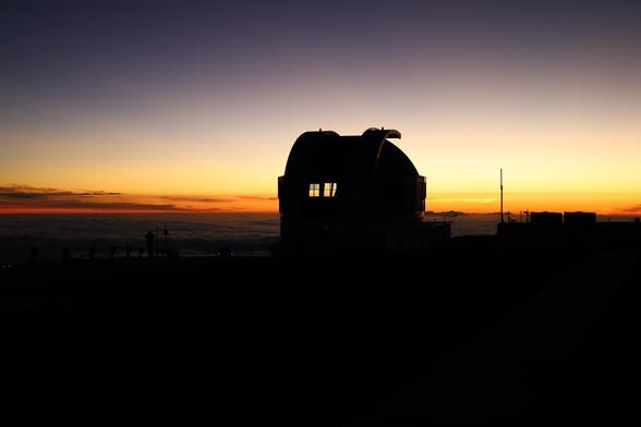 Silhouetted against the western horizon shortly after sunset, UKIRT’s dome has opened for a night of astronomy. Vents are open to cool the telescope and we can see the sky through the dome in places.