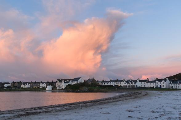 pink cloud over village around a bay