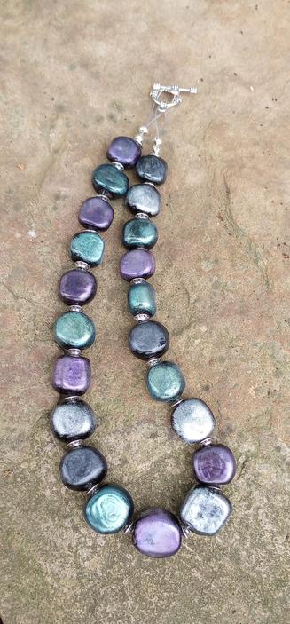 Handmade Hot Glass lampwork necklace in opaque glass with added mica powder in purple, silver and teal.