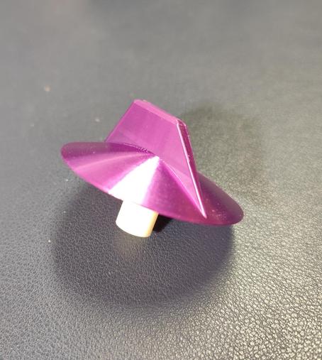 A 3d print of a micro wave rotary knob. The knob is purple with a white stem.