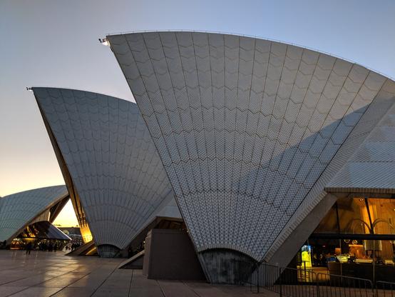 Image displays the curved shells of the Sydney Opera House in evening twilight.