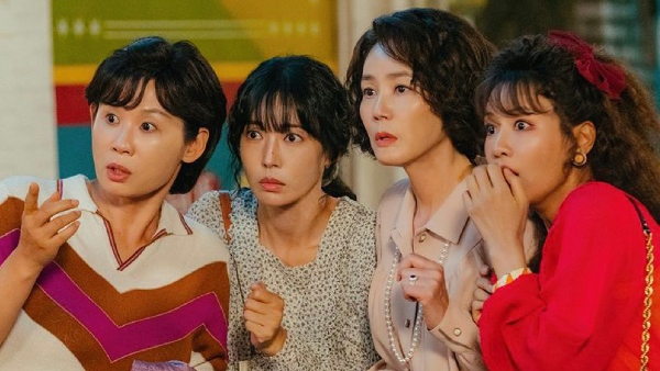 A scene from the 2024 South Korean drama "A Virtuous Business" with Kim Sun Young, Kim So Yeon, Kim Sung Ryung, & Lee Se Hee standing huddled together, shoulders touching looking shocked at something in front of them.