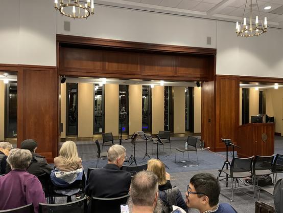 Seating in the lounge with space for the performers on front of slit windows with a view of Lincoln Center