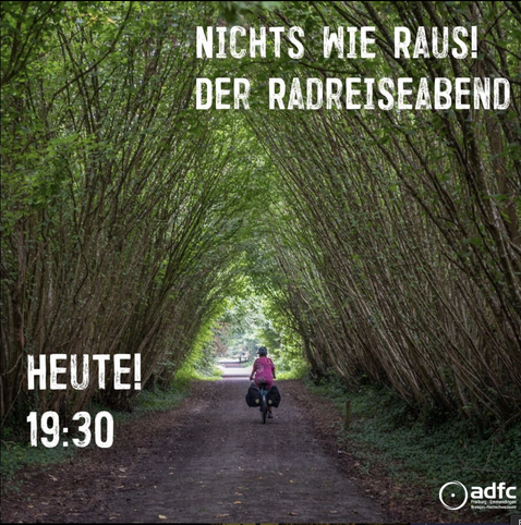 Eine Fahrradfahrerin fährt auf einem Radweg durch einen Tunnel aus Ästen