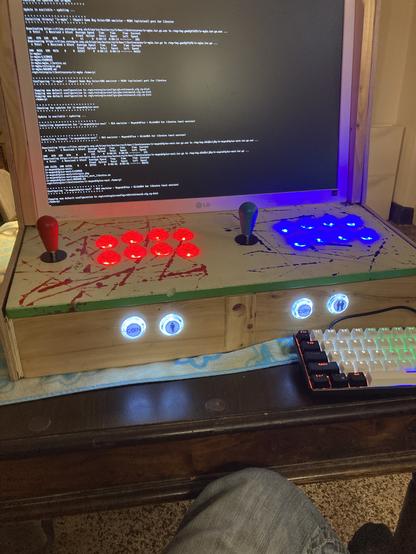Ansicht eine selbstgebauten Arcade Automaten. Leuchtende blaue und rote Tasten mit Joystick und Holz. Bildschirm lädt gerade