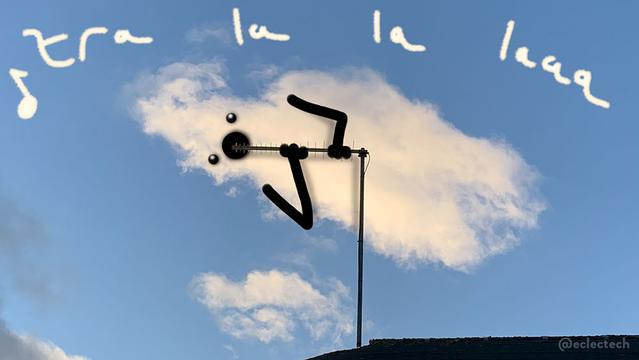 A photo of a white fluffy cloud against a blue sky. The roof of a house sits as a silhouette along the bottom of the photo, with a TV aerial sticking directly up, with the aerial bit pointing left. I have drawn a face and arms on the cloud, so it's mouth is open by the end of the aerial, and it is holding on to it with both hands. Above I have scribbled "tra la la laaa" in slightly cloudy writing, because sometimes I feel like I need to provide some additional evidence of my cloud creatures, and this is probably pushing it quite a bit.