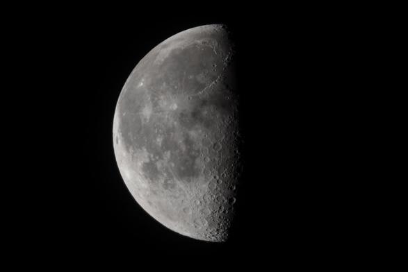 Der abnehmende Mond kurz vor Halbmond fast formatfüllend am dunkeln Nachthimmel