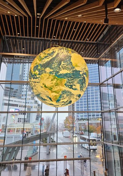 A giant rotating globe hanging from the wooden ceiling of the convention center