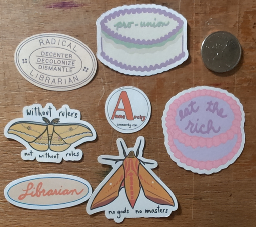 Stickers that say: pro-union; radical librarian — decenter, decolonize, dismantle; without rulers, not without rules; no gods, no masters; eat the rich; and librarian.  There is a Canadian quarter for scale.