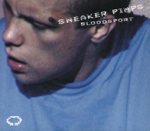 Album cover with a close-up of a young man with a serious expression, wearing a blue shirt. There is a noticeable mark on his forehead. The text "SNEAKER PIMPS BLOODSPORT" is superimposed in white font.