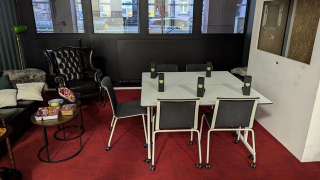In rot gehaltenes Kaminzimmer mit Tisch, Würfeltürmen und Knabbereien.