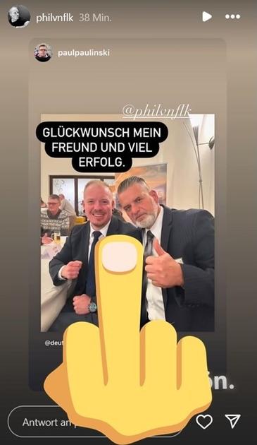 (Bearbeiteter) Screenshot Instagram. Account "philvnflk" (Phil von Flak) teilt Foto, auf dem er und Thorsten Heise, beide im schwarzen Anzug, in die Kamera blicken. Heise hebt den linken Daumen. Darüber Text "Glückwunsch mein Freund und viel Erfolg." 
Der darüber gelegte gelbe "The Finger" in der unteren Hälfte stammt von mir.