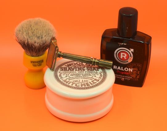 A patinaed GEM Micromatic Clog-Pruf Peerless lying on a ceramic tub of The Fat between a bottle of Ralon splash and a beautiful butterscotch Zenith badger brush.