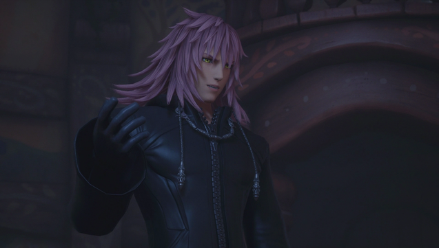 Marluxia stands in a dark room, gesturing with his hand and talking to someone off-screen.