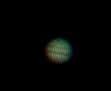 Jupiter as a somewhat fuzzy greenish ball, dark bands are visible at the poles and the tropics.