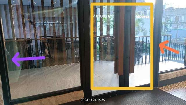 Photo of the side entrance of the same Starbucks store with a ramp for PWD (orange arrow). The photo is taken from inside the store. Where the purple arrow is pointing, there is a bicycle parked, out of view and out anyone's way, a good distance from the door.