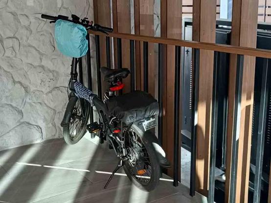 Photo of a bicycle parked in a corner and locked to the railing