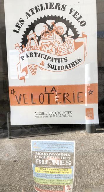 Affiche de l’atelier en vitrine annonçant un atelier vélo participatif et solidaire. Sous l’affiche une plus petite affiche pour la projection du film nous n’avons pas peur des ruines.