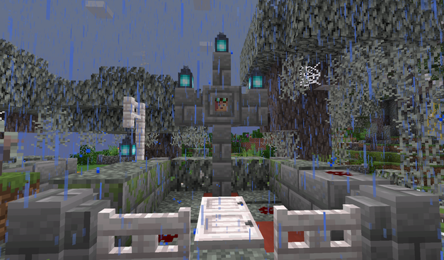 A screenshot from Minecraft showing a grave in the rain. The gravestone is a cross of stone brick surmounted by blue lanterns. A player's head with pink hair and steampunk goggles is mounted in the center of the cross. The decor is pale and gray with bits of red here and there, including patches of redstone to simulate splattered blood. Pale oak trees surround.