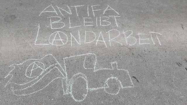 Foto. Kreide auf Asphalt: "Antifa bleibt Landarbeit"