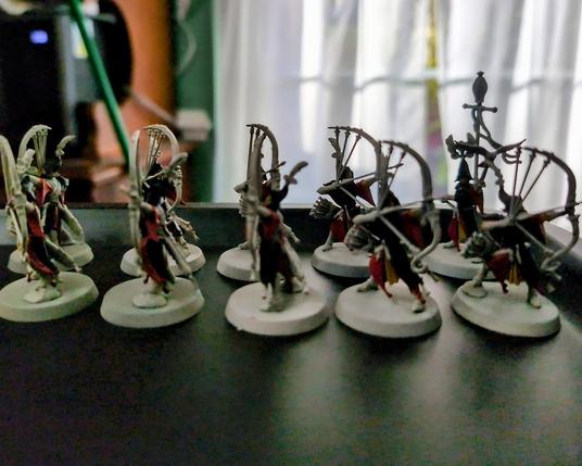 Lumineth Realm-Lords Sentinels miniatures from Games Workshop partially painted with black-steel armor, red robes, and yellow under-robes.