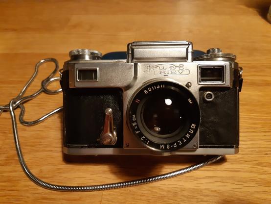 Kiev 3 analog camera with a Jupiter 50mm f2 lense leaning on a table.