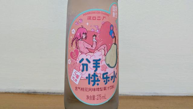 A bottle of pear soda with an illustration of a woman holding a damaged heart.