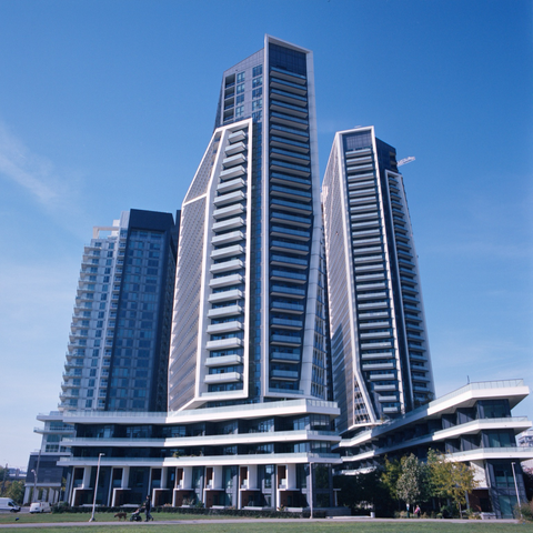 A wide angle photo of a cluster of modern condominiums grouped like an approaching chevron.