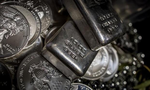Lingotes y monedas de plata sobre fondo oscuro. (Getty Images)
