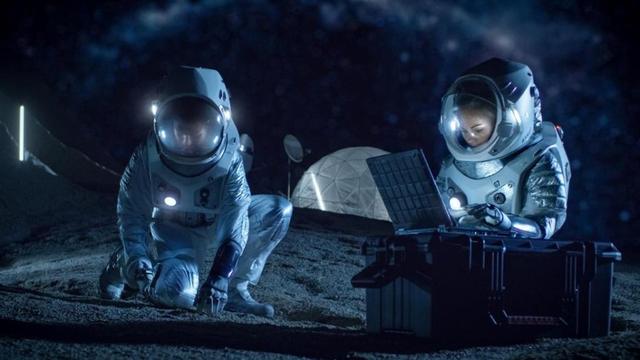 Astronauts on surface of a moon working with computer and plants.
