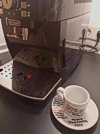 Espresso- Tasse neben einem kaffeevollautomaten