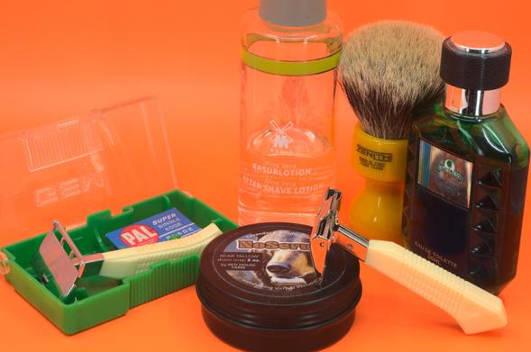 An Ever-Ready Natural Angle (British Featherweight) leaning on a tin of NoScrub soap with a GEM Featherweight in its display case, a bottle of Mühle splash, Stirling Island Man Frag and a beautiful butterscotch Zenith badger brush in the background