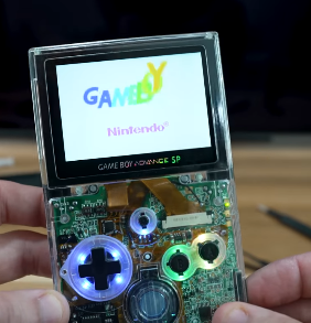 A booting Gameboy Advance SP but it's in a clear transparent case without hinges, making it look like a Gameboy Pocket