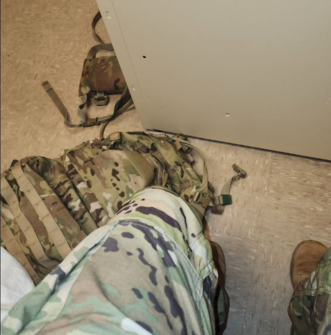 An apparently selfie by Kiberphant0m shows them wearing Army fatigues from the waist down. Also pictured at the person's feet is a camouflaged backpack.