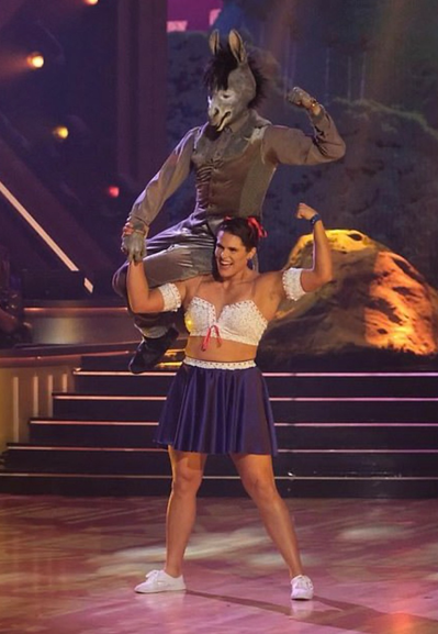 Ilona Maher dressed as Luisa from Encanto. Ilona is very strong and is lifting her partner, who is dressed as a donkey, onto her shoulders.