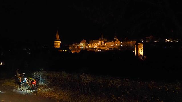 "Skyline" von Warburg in der Nacht. Die mittelalterlichen Gebäude werden angestrahltZu sehen sind ein Wachturm,ein ehemaliges Kloster mit Klosterkirche, das Rathaus zwischen den Städten und der Turm der Altstadtkirche. Im Vordergrund ein beleuchtetes Fahrrad