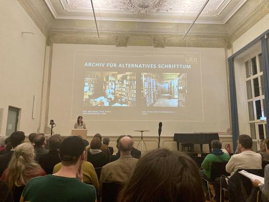 Präsentation mit zwei Abbildungen des Magazins des afas vor einem Plenum