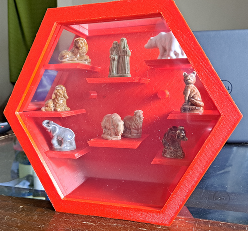 The same display case, but now the front panel is on and it holds a small collection of Red Rose Tea ceramic figurines.