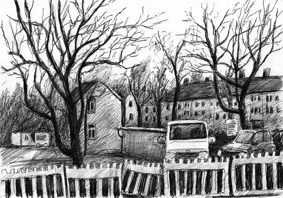 Winter-trees, parking cars and some houses behind a construction site fence.