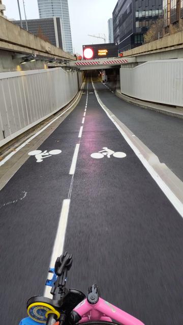 Piste cyclable toute neuve qui passe dans une trémie avec l'avant de mon vélo en premier plan