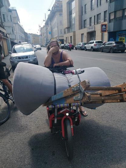 A person on a cargo bike loaded with a rolled-up mattress, a ladder and some smaller stuff. #cargobike #messlife #greenlogistics #lastmile #vienna #hermes #cooperative #collective #kollektiv #carryshitolympics