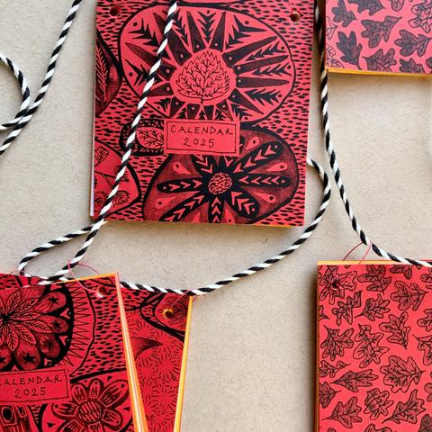 The cover of a small calendar with illustrations of patterns and leaves.