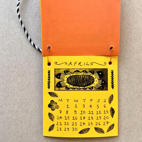 The April page of the calendar with a big sunflower-type illustration.