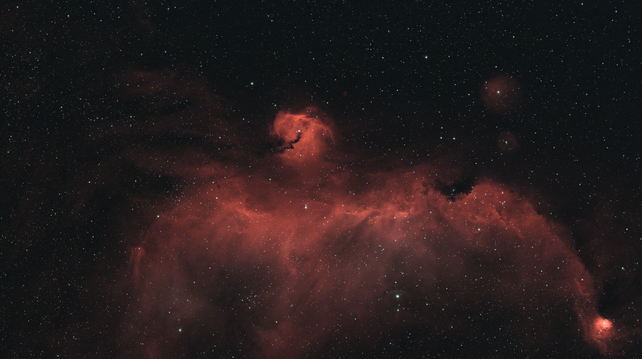 Nébuleuse de la mouette. On voit un nuage d'hydrogène rouge dans forme vague d'oiseau qui déploie ses ailes