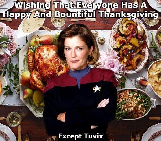 Captain Janeway from Star Trek with a holiday spread of food behind her. Caption reads: Wishing That Everyone Has A Happy And Bountiful Thanksgiving… Except Tuvix“