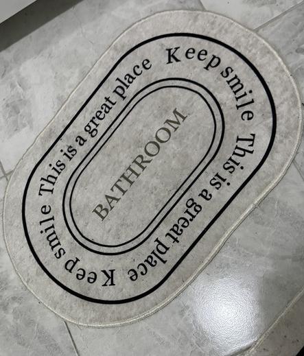 A bath mat with catastrophic kerning reading: 
Keep smile,
This is a great place